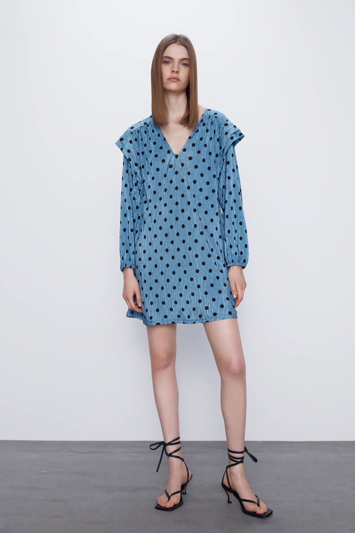 Manga larga, puño elástico, estampado de lunares, escote a pico, corte recto y tejido amplio. Vestido de lunares de las rebajas de Zara. Rebajado a 12,99 euros y disponible en todas las tallas.