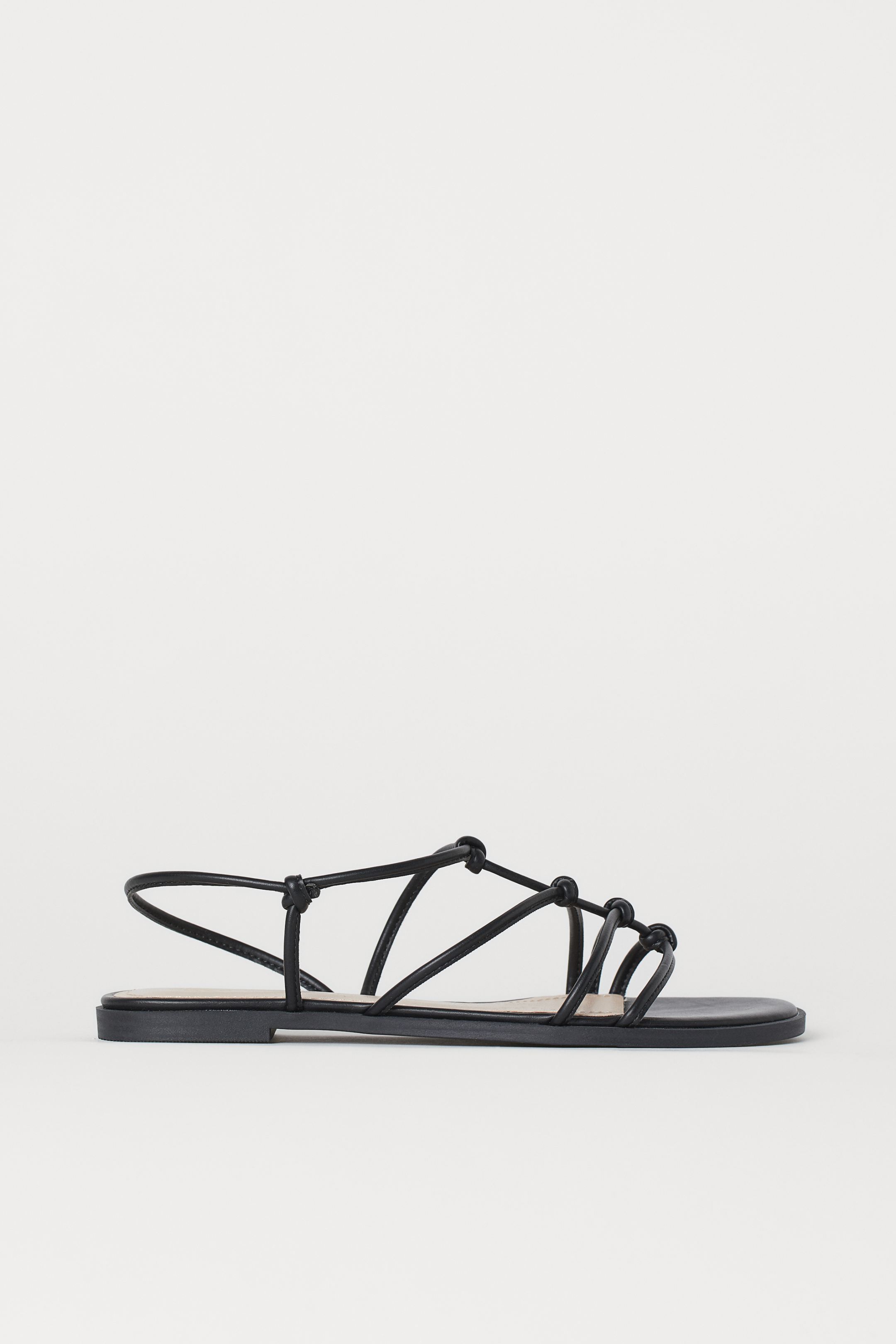 Un básico muy clásico que pega con todo: sandalias planas de tiras negras de las rebajas de H&M. Las más funcionales y prácticas de nuestra selección. (14,99 euros).