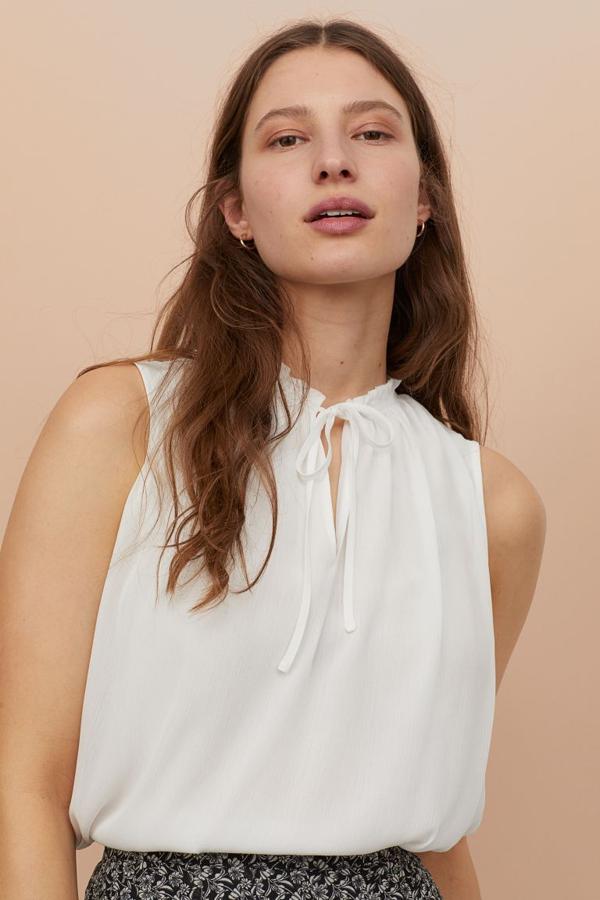 Otra de las propuestas de H&M sin mangas es esta bonita blusa en color blanco y tejido ligeramente arrugado con cuello fruncido de volante. De 19,99 euros ha pasado a costar 10,99 euros y está disponible entre las tallas 32 y 50.