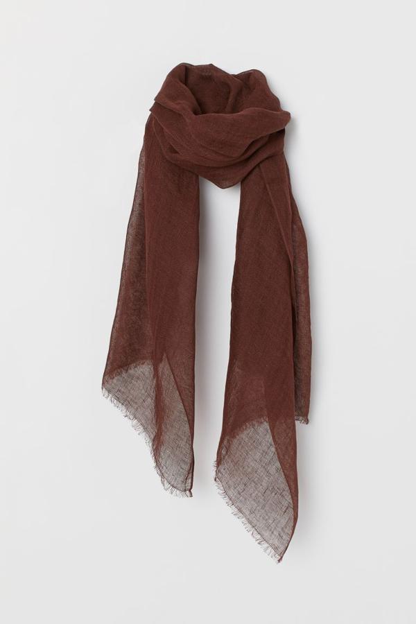 Otro de los complementos de H&M en marrón chocolate es este fular de lino con acabado desflecado que costaba 19,99 euros y ahora podemos comprar por 15,99 euros.