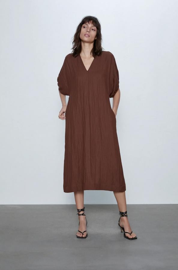 En Zara hemos encontrado este vestido midi de escote pico y manga abullonada hasta el codo. Con bolsillos laterales ocultos en la costura, está rebajado y de 59,95 euros ha pasado a costar 19,99 euros. Solo queda en la talla XL.