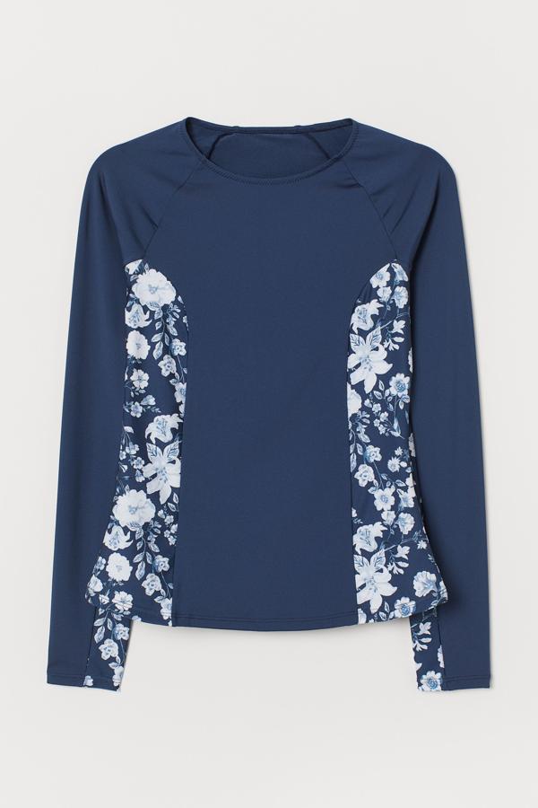 Esta camiseta de baño en azul oscuro con paneles estampados en los laterales y manga larga está rebajado a la mitad de su precio, y ahora tiene un precio de 9,99 euros.