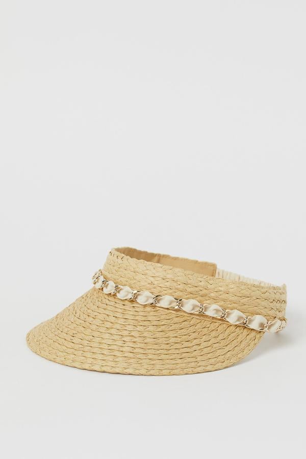 Esta visera en paja trenzada con adorno y cadena de metal cuenta con cinta anti sudor de tela y tiene un precio de 6,99 euros.