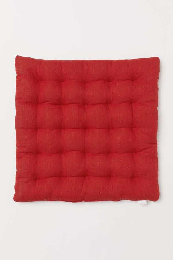 En color rojo, aunque está disponible en otros tonos, este cojín para silla en mezcla de lino y viscosa tiene un precio de 9,99 euros.