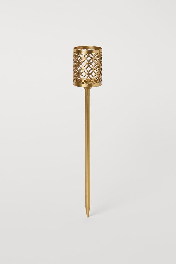 Este portavelas de metal con candelabro en un clavo para poder enterrarlo o ponerlo en una maceta tiene una altura aproximada de 6,5 centímetros y un precio rebajado de 3,99 euros.