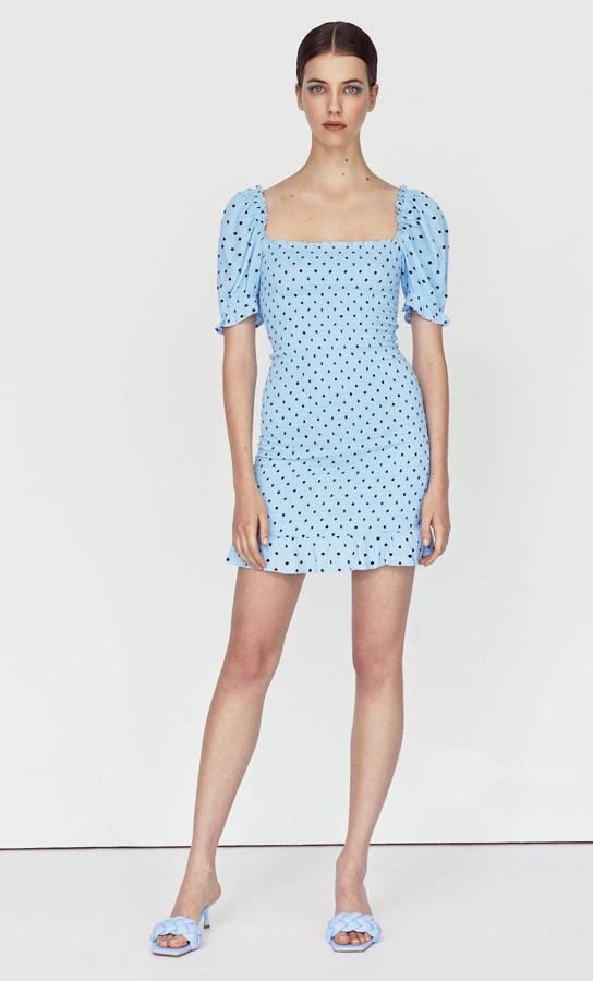 Este vestido corto con escote recto y manga corta abullonada cuenta con tejido de nido de abeja en el cuerpo. En color azul celeste y detalle de volante en el bajo, tiene un precio de 25,99 euros.