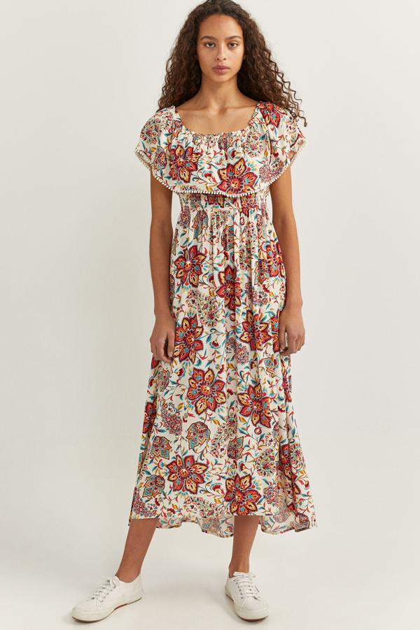 Con escote cuadrado y hombros con volante, este colorido vestido con fondo crudo y estampado floral cuenta con goma en la cintura y tiene un precio de 29,99 euros. Es de Springfield.