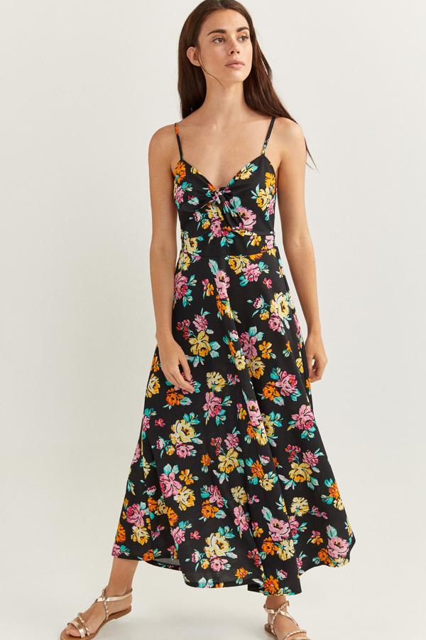 En color negro y con flores de colores, este vestido con tirantes y falda de vuelo cuenta con detalle de nudo en el escote. Es de Springfield y con las rebajas tiene un precio de 19,99 euros.