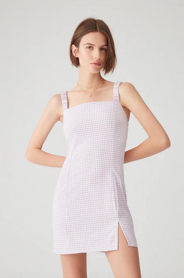 Pull&Bear ha combinado dos bonitas tendencias en este vestido de cuadro vichy en color lila con escote recto, bajos con abertura y tirantes anchos fruncidos. Tiene un precio de 17,99 euros y está disponible en las tallas XS, S, M y L, aunque las dos primeras se están agotando.