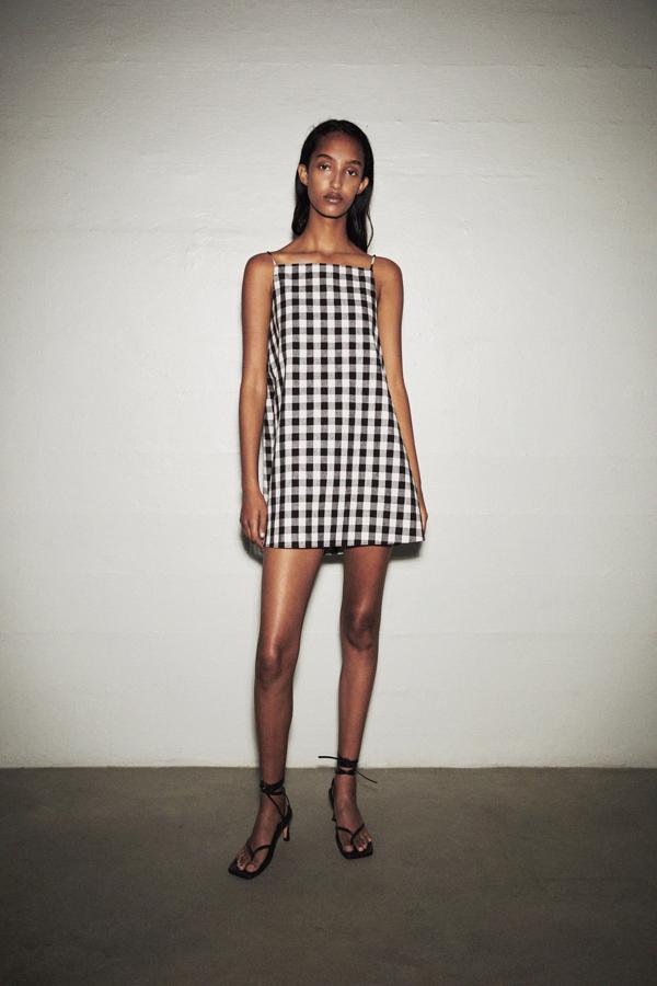 En mezcla de lino, con escote recto y tirantes finos ajustables con lazada en la espalda, este vestido corto de Zara tiene un precio de 25,95 euros y está disponible entre las tallas XS y L.