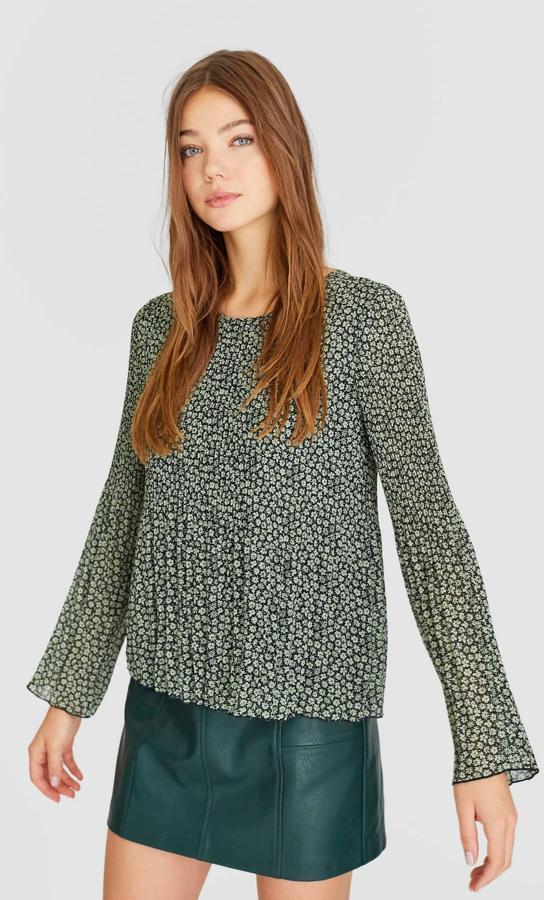 Fondo negro y estampado minimalista de flores en color caqui para esta blusa plisada que antes costaba 17,99 euros y ahora podemos encontrar por 7,99 euros únicamente en la talla XS.