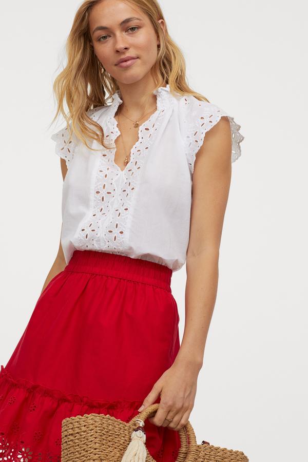 Confeccionada en algodón vaporoso, con escote de pico festoneado y cuello elevado fruncido, esta blusa de mangas japonesas y bordado inglés en el frontal cuesta 24,99 euros y está disponible en la talla 36 y entre la 44 y la 50, aunque todas se están agotando.