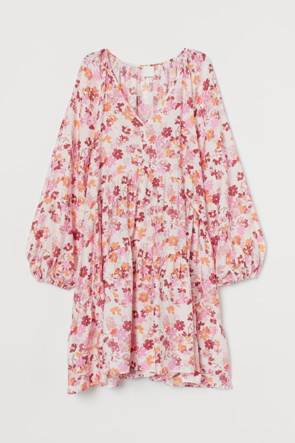 Diseño corto evasé en mezcla de viscosa para este vestido de H&M con escote de pico profundo, manbas raglán holgadas con elástico en los puños y costuras escalonadas en la falda. Con flores en tonos rojos, naranjas y rosas, tiene un precio de 19,99 euros y está disponible entre las tallas XS y XXL.