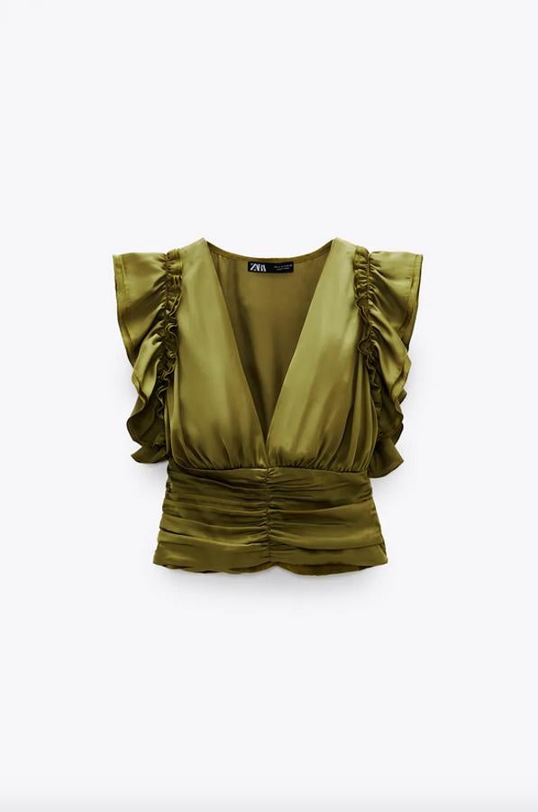 De escote de pico y manga sisa con volantes, este cuerpo satinado en color oliva tiene el bajo acabado en frunces. Una propuesta atractiva y original que cuesta 25,95 euros y estará pronto disponible en la web en las tallas S, M y L.