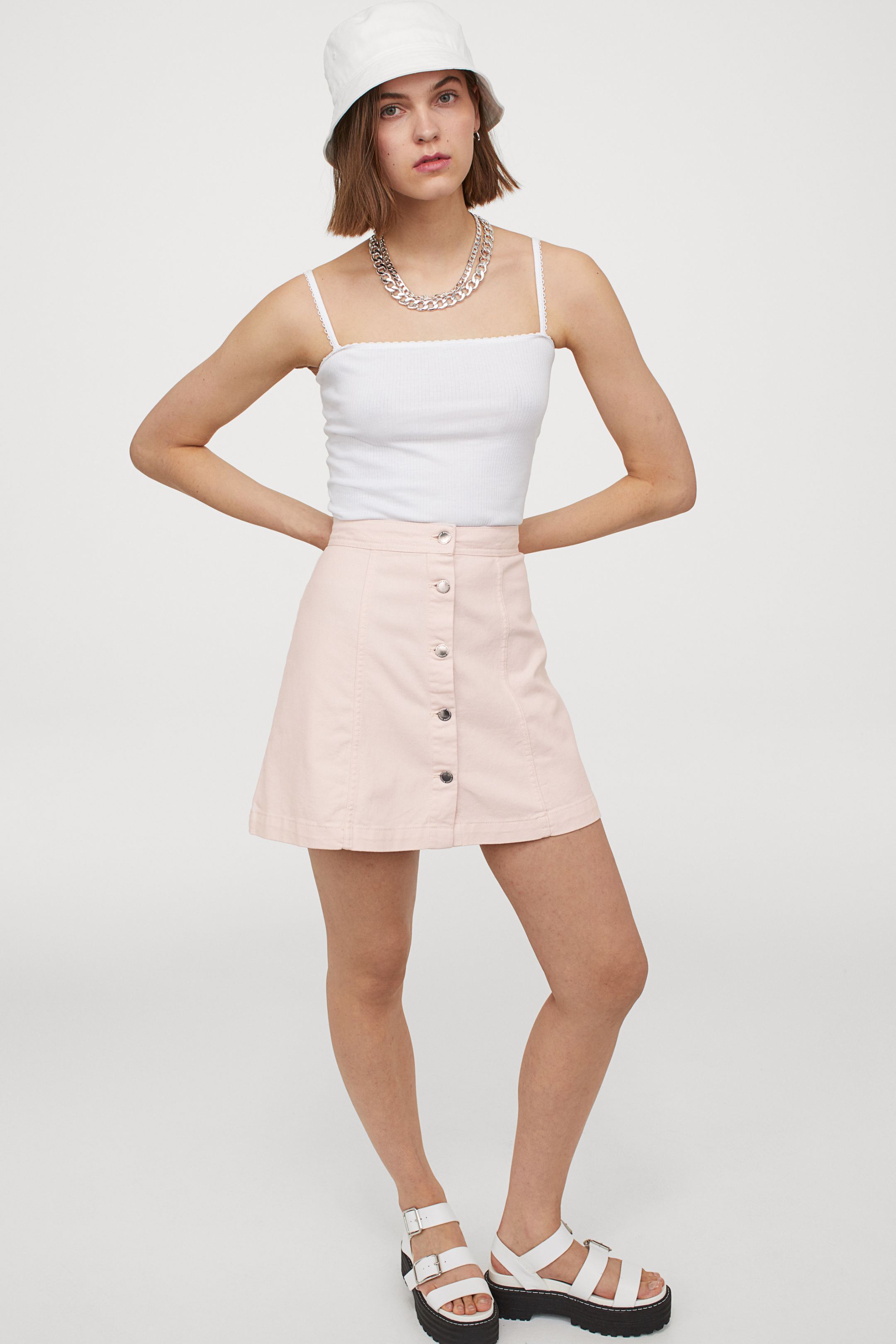 Rosa claro, cierre de botones y cintura alta, un básico muy versátil al que sacar partido esta temporada con todo. Falda de corte evasé de la nueva colección de H&M. (19,99 euros).