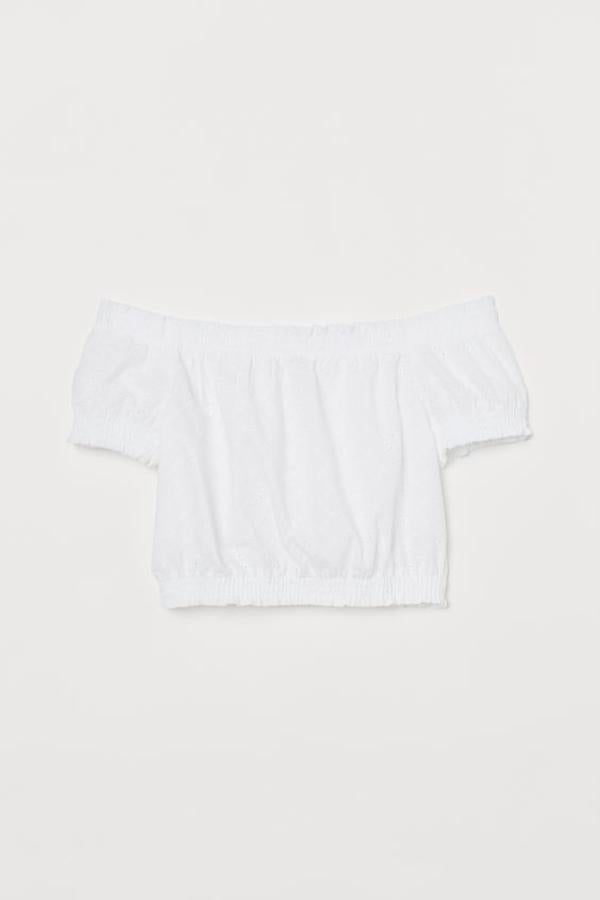 Diseño cropped en tejido de algodón con bordado inglés para esta blusa de mangas cortas de H&M, con fruncido en la parte superior, mangas y bajo. De 14,99 euros ha pasado a 6,99 euros y está disponible en las tallas 34 y entre la 40 y la 48.