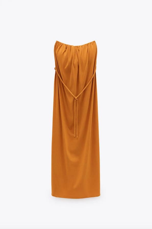 Confeccionado en algodón orgánico, este vestido midi de escote recto con hombros al aire es de Zara y viene con detalle de cinturón tipo cordón a tono y forro interior elástico en la parte superior. Cuesta 19,95 euros y está disponible en las tallas S, M y L.