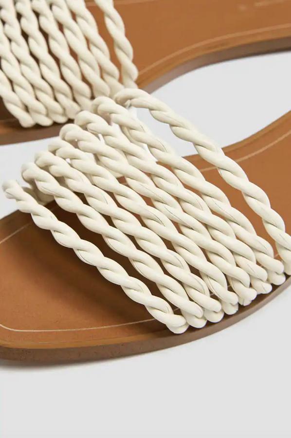 Con tiras trenzadas en color blanco en el empeine, estas sandalias planas de Pull&Bear cuestan 19,99 euros y están disponibles entre los números 35 y 41.
