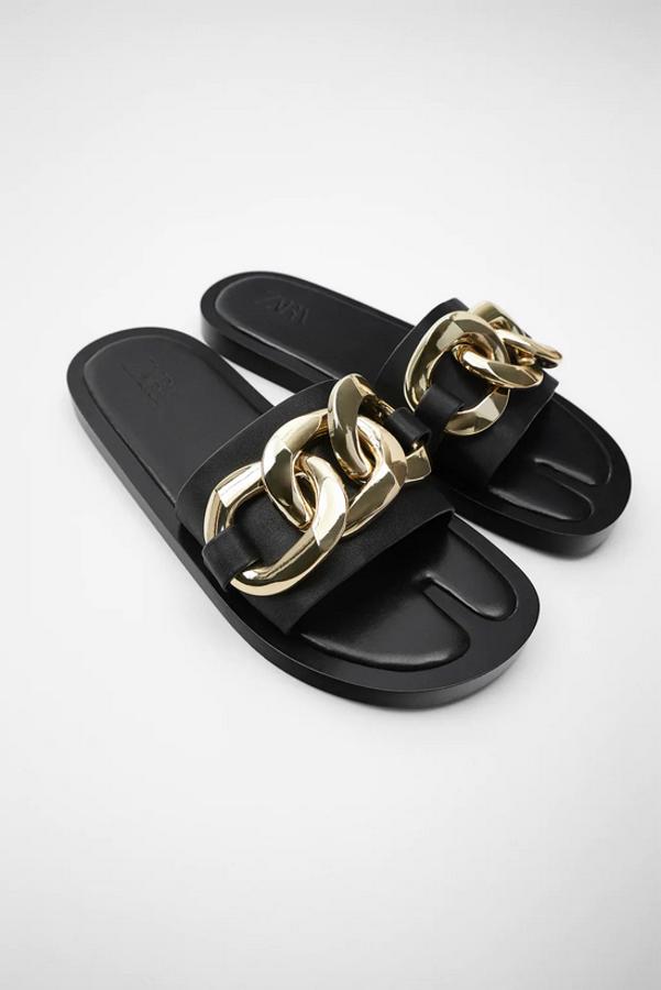 Con cadena dorada sobre la tira negra en el empeine, esta sandalia plana de Zara cuesta 35,95 euros y solo queda en el número 36, aunque en la web está previsto que regrese en el resto de los números hasta el 42.