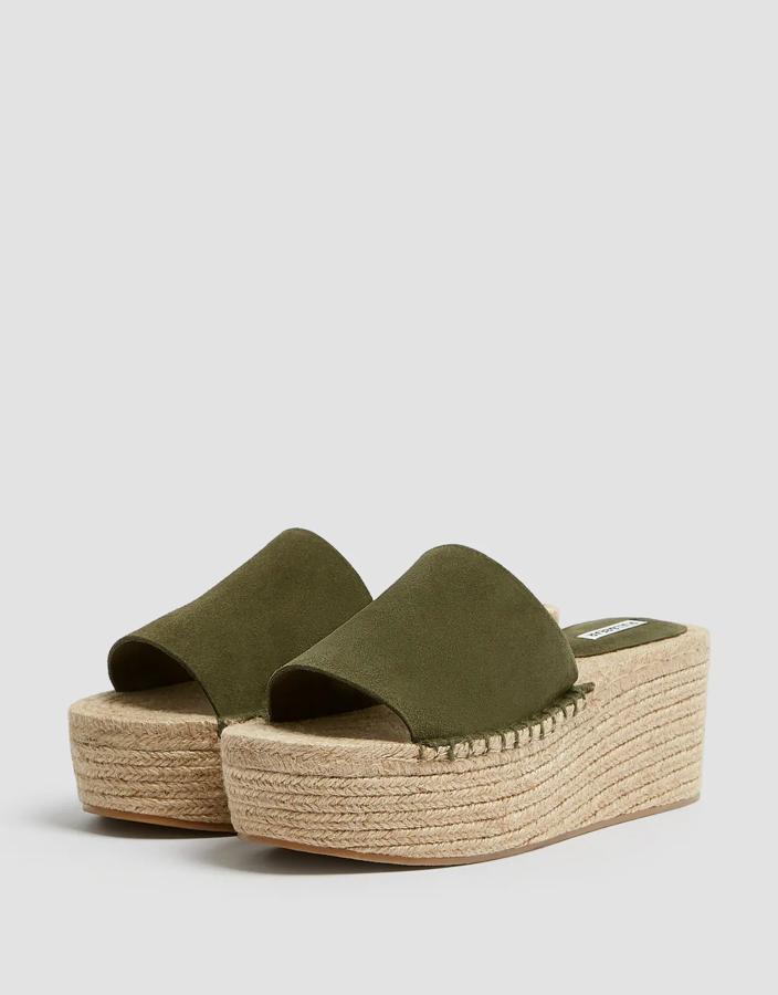 Esta cuña con plataforma de yute y tira ancha de piel en color verde cuenta con una altura de 4,5 centímetros. Disponible en otros colores, tiene un precio rebajado de 15,99 euros.