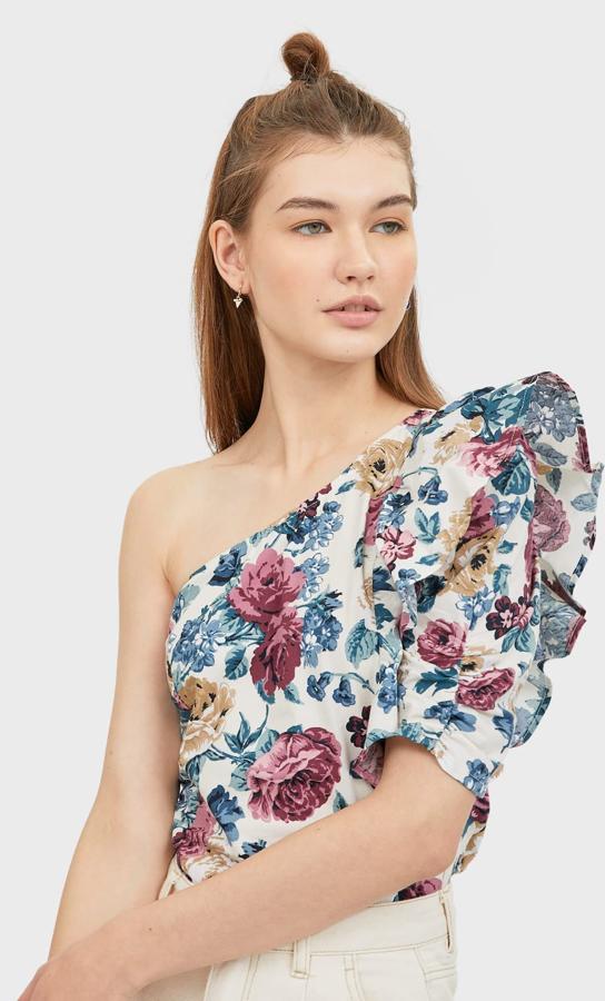 Este top asimétrico de flores con volante en una manga está rebajado y ahora tiene un precio de 7,99 euros.
