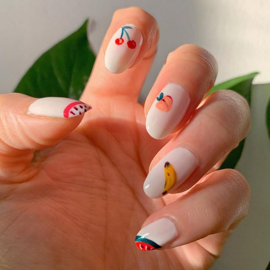 ¿Hay un diseño más veraniego que las frutas? Esta manicura en color nude con sencillos dibujos de frutas en cada uña es toda una inspiración.