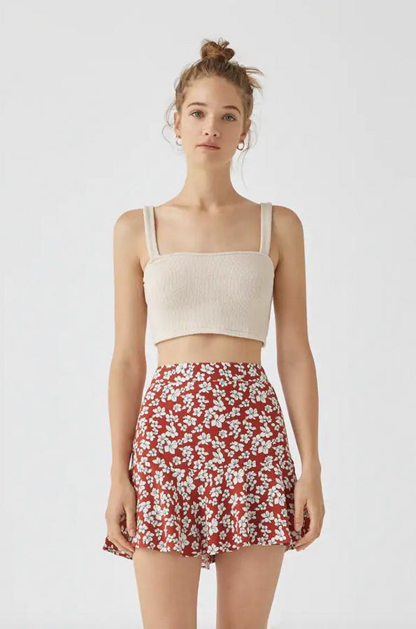 Fondo rojo y estampado de flores blancas para esta falda bermuda de Pull&Bear con detalle de volante confeccionada en viscosa. Tiene un precio de 15,99 euros y está disponible entre las tallas S y XL.