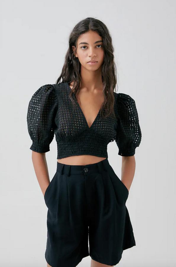 Entre nuestras propuestas favoritas de Pull&Bear está esta camisa en color negro y tejido cuadrillé con detalle de goma canilla en la cintura y escote en forma de pico. Con un precio de 17,99 euros, podemos encontrarla entre las tallas XS y L.
