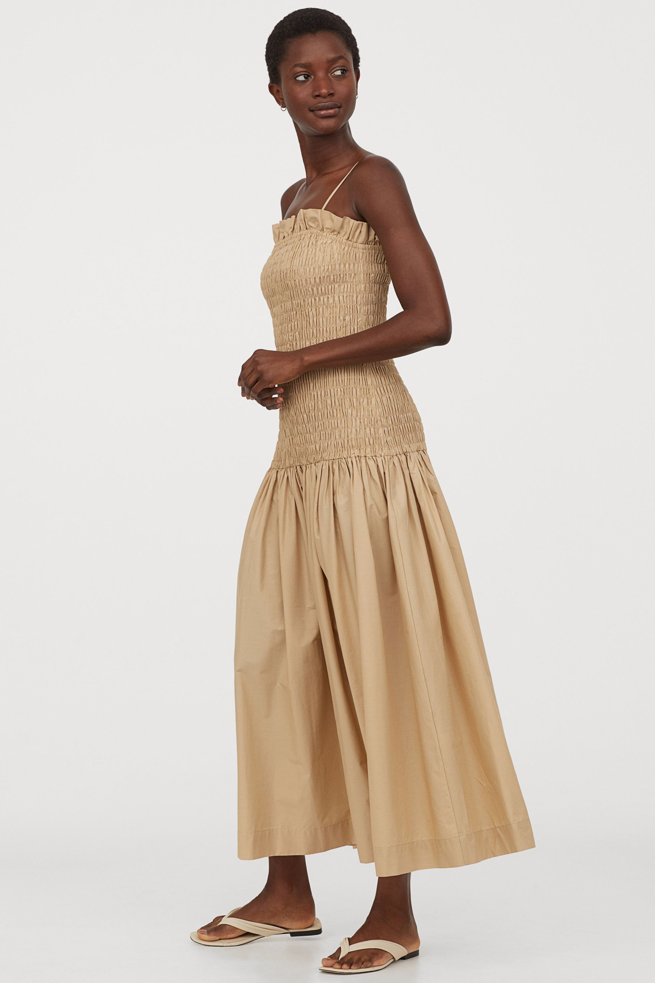 Vestido largo popelin de corte sirena con tejido de algodón, cuerpo elástico y falda holgada con mucho volumen. En color beige. De H&M. (49,99 euros).