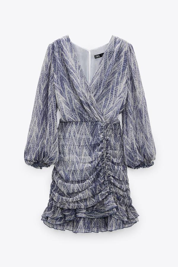 Con estampado de piel de serpiente, este vestido mini con escote de pico y manga larga cuenta con bajo asimétrico acabado con frunces y volante s y tiene un precio de 39,95 euros.