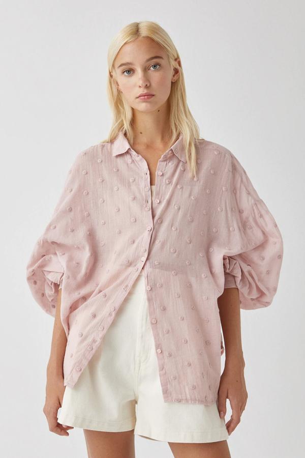 En tejido de plumeti, esta camisa rosa con detalle de bordados y manga larga también está disponible en blanco. Tiene un precio de 19,99 euros.