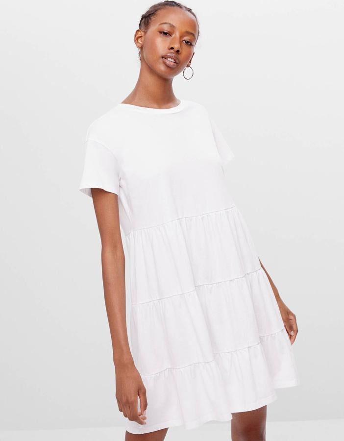 En Bershka encontramos este vestido blanco, uno de sus más deseados. De corte babydoll, y disponible también en naranja o negro, tiene un precio de 12,99 euros.