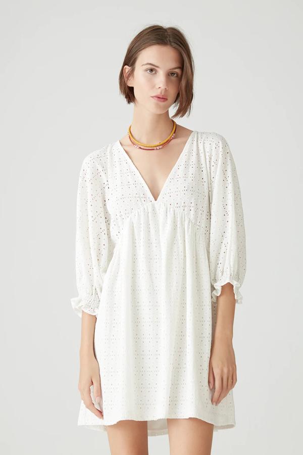 Este vestido blanco con bordado suizo cuenta con goma bajo el pecho y manga corta. Con escote en forma de pico, es de Pull & Bear y tiene un precio de 29,99 euros.