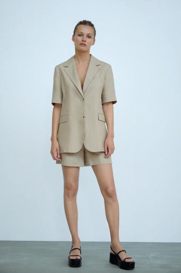 En color visón claro, esta blazer de cuello solapa con manga corta es de Zara y viene con bolsillos de solapa en deltantero y bajo con abertura en la espalda. Con un precio de 59,95 euros está disponible entre las tallas XS y XL.