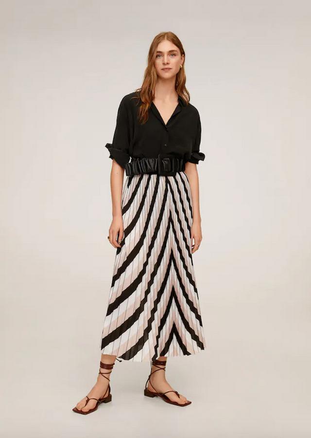 Tejido plisado y estampado geométrico en rosa pastel, blanco y negro para esta falda midi con diseño recto de Mango. Con un precio de 49,99 euros, está disponible entre las tallas XS y XL.