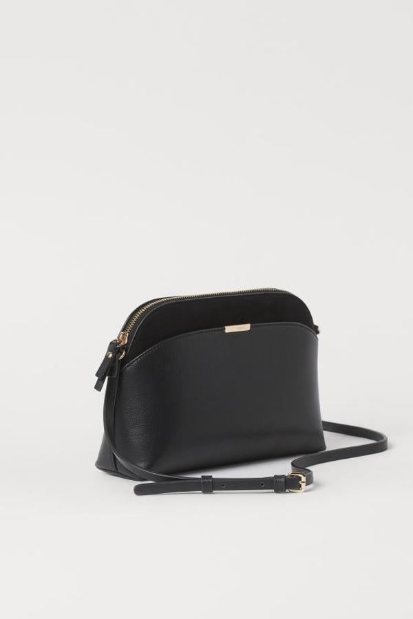 En color negro, con detalles dorados en el cuerpo y el asa larga, esta bandolera con cremallera superior y compartimento exterior tiene un precio de 17,99 euros.