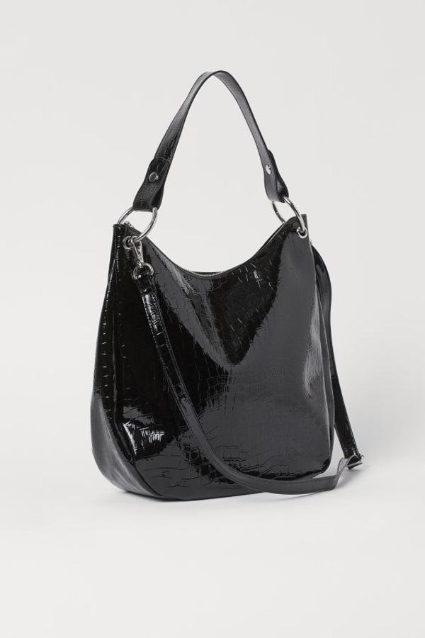 Para las que son incapaces de prescindir de un bolso grande, H&M tiene este bolso hobo con estampado de piel de cocodrilo en charol, correa extraíble y asa superior. Cuesta 29,99 euros y puedes comprarlo también en negro mate, beige claro y beige grisáceo.