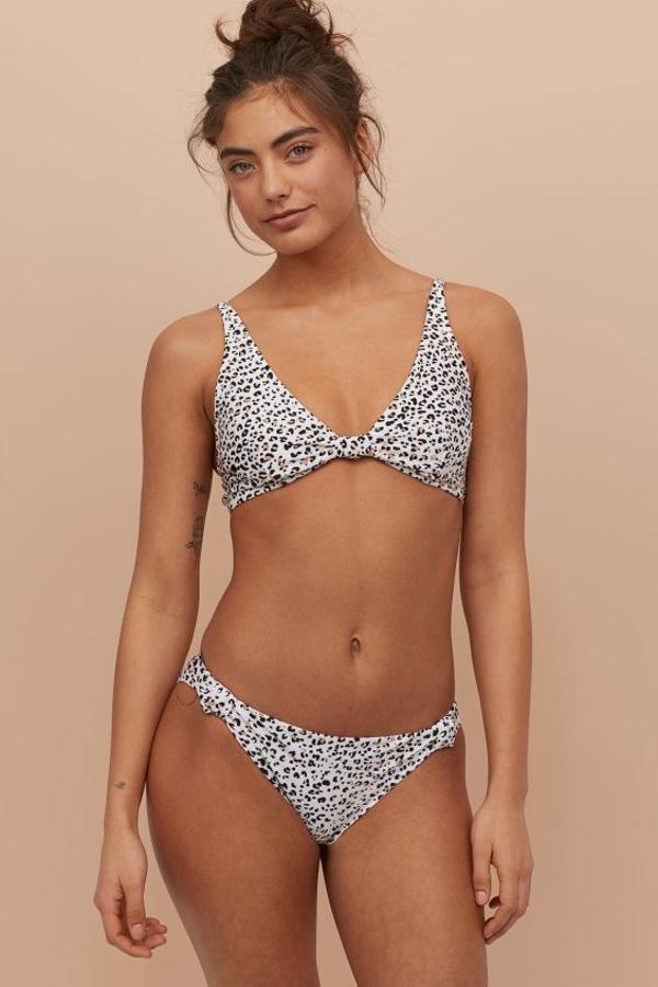 Fondo blanco con estampado en tonos beige y negros para este bikini de H&M con top acolchado (17,99 euros) y braguita con detalle anudada en los laterales (6,99 euros). Ambas prendas se están agotando en varias tallas.