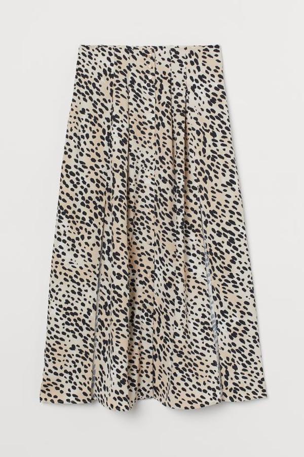 Para esta bonita falda larga con aberturas H&M ha apostado por la versión clara del estampado de leopardo. Confeccionada en tejido de viscosa, de talle alto con pliegues y cierre de botones frontales en color crema, cuesta 49,99 euros. Está disponible únicamente en la talla 50.