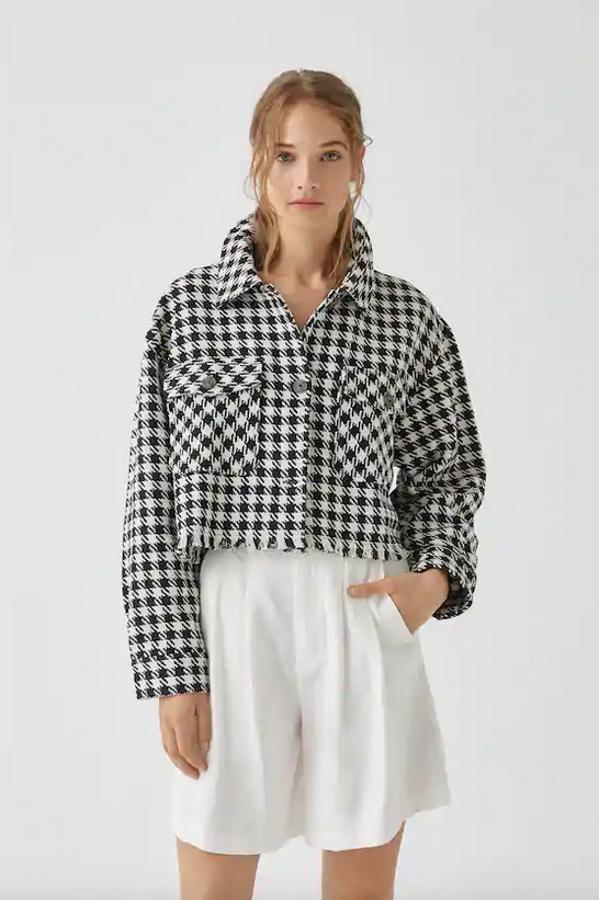 Con estampado de cuadros blancos y negros, esta sobrecamisa de Pull&Bear viene con manga larga, cuello clásico, bolsillos de tapeta y detalle de flecos en el bajo. Tiene un precio de 29,99 euros y está disponible entre las tallas XS y XL.