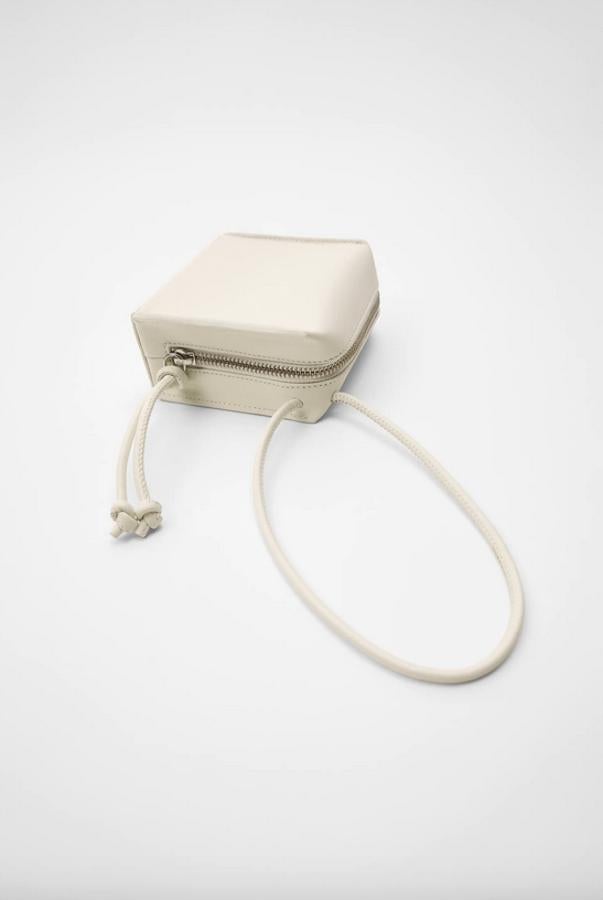 Las formas de los bolsos pueden ser infinitas y esta de Zara viene en color crudo con cuerpo de piel geométrico y asa de mano tubular. Con cierre de cremallera tiene un precio de 59,95 euros.