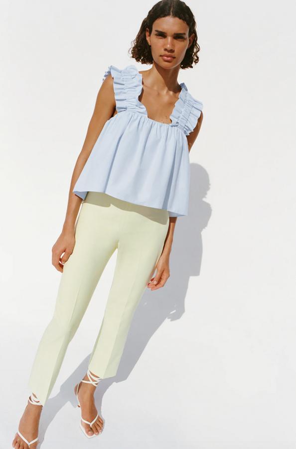 Otro top en azul cielo de Zara es este confeccionado en popelín, con escote recto, tirantes anchos con volantes y bajo asimétrico. Cuesta 22,95 euros y está disponible en las tallas XS, M y L.