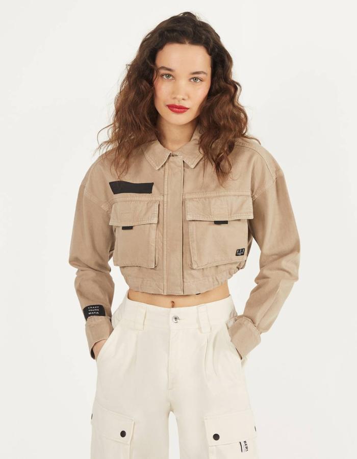 Entre las propuestas de Bershka está esta cazadora cropped en color piedra, con cuello solapa y manga larga con puños abotonados. Con dos bolsillos frontales con solapas, cierre frontal con botones metálicos y bajo ajustado por goma elástica, pertenece a la colección sostenible de Bershka y tiene un precio de 22,99 euros. Está disponible entre las tallas XS y L.