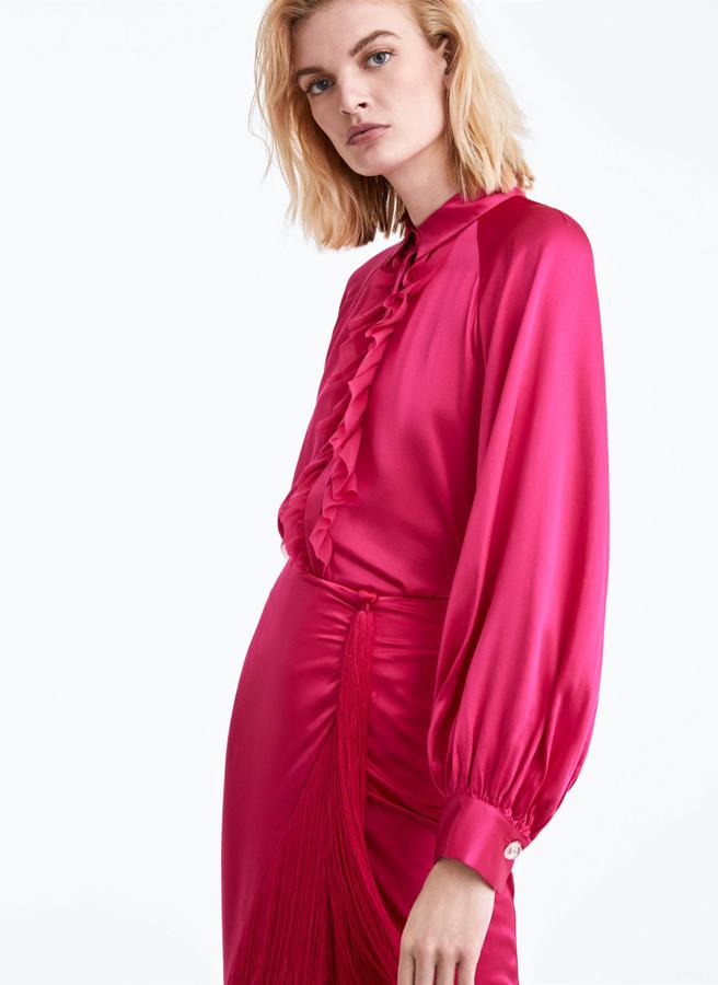 El tejido satinado da un extra de elegancia. Tanto es así, que una camisa de este estilo es perfecta para incluir en un look de invitada. Y si no nos crees, ficha esta en color fucsia que hay en Uterqüe (34.95 euros) y que tiene una falda midi de flecos a juego.