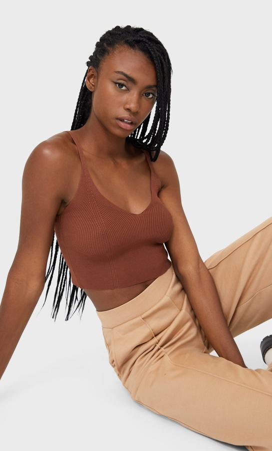 En camel oscuro y confeccionado en punto, este bralette de Stradivarius viene con escote de pico y tirantes finos. Cuesta 9,99 euros y está disponible entre las tallas XS y XL, y en color negro.