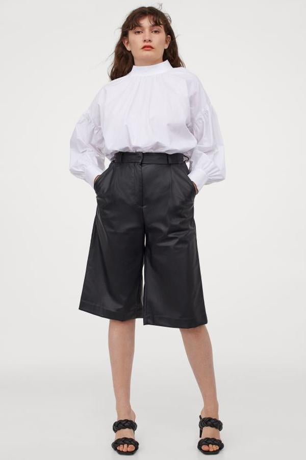 En H&M hemos encontrado estas bermudas de piel sintética en color negro, con talle alto y pliegues delanteros. Viene con corchetes ocultos y bolsillos al bies y cuesta 29,99 euros. Podemos encontrarlo entre las tallas 32 y 50.