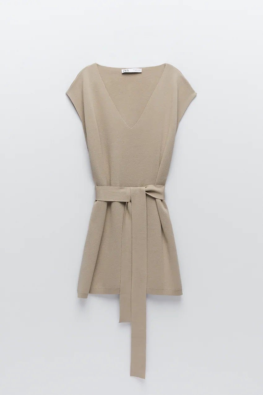Chaleco de punto en tono beige con escote a pico, cinturón y manga sisa. De la nueva colección de Zara. (29,95 euros).
