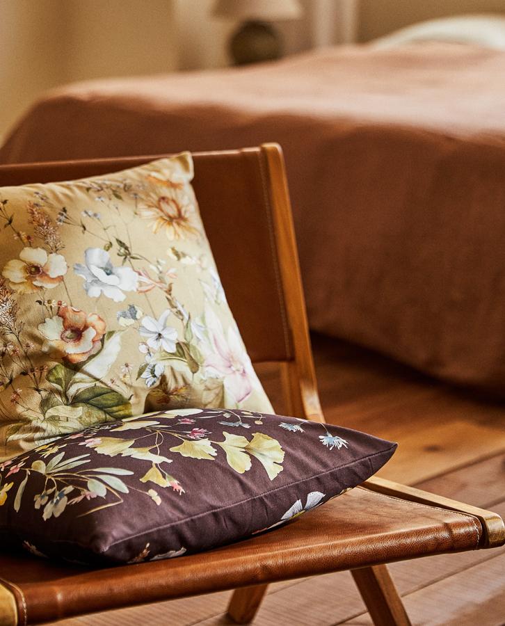 Con unas medidas de 45x45 centímetros, esta funda de cojín con estampado de flores en diferentes colores tiene un precio de 9,99 euros.