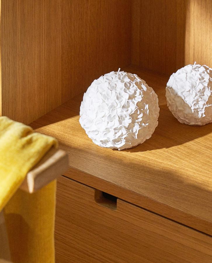 Con forma redondeada y relieve flora en color blanco, esta vela está disponible en dos tamaños. Desde 7,99 euros.