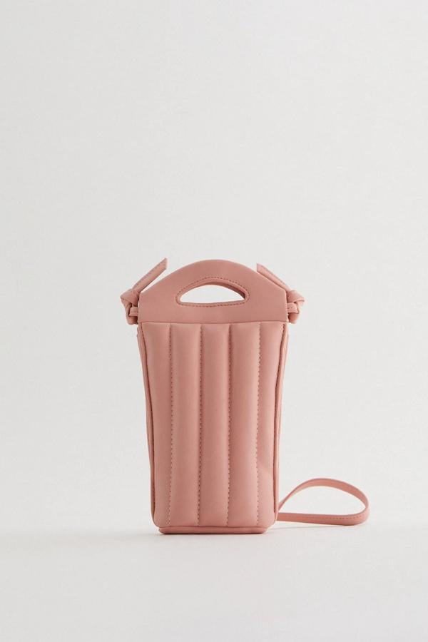 Este bolso bandolera en formato portamóvil de color rosa cuenta con cuerpo acolchado y tiene un precio de 17,95 euros. Es de Zara.
